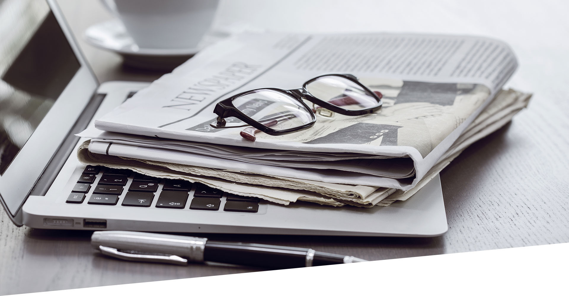 Arbeitsplatz mit Zeitungen und Laptop
